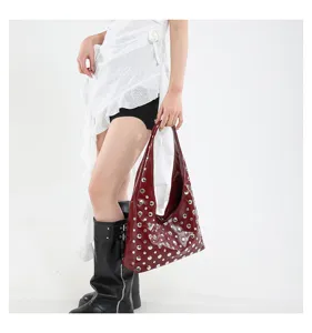 Detailed view of dark red studded shoulder bag, punk style underarm bag, fashion accessory.