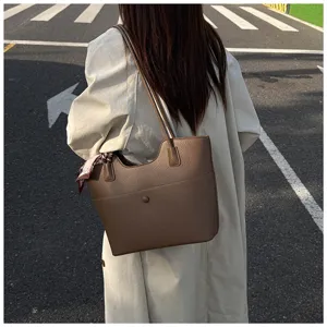 Detail shot of the brown leather tote bag showcasing its fine texture and stylish wear.