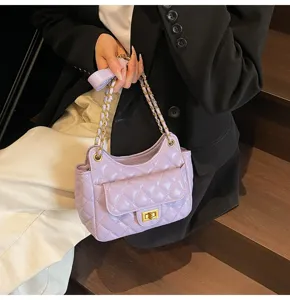 Detailed shot of a light purple quilted shoulder bag with gold chain strap and metal lock.
