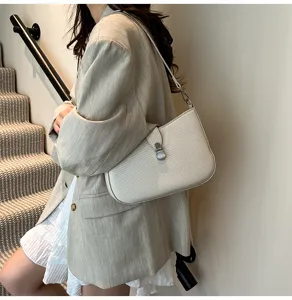 Detail view of women retro shoulder underarm bag featuring texture and metal clasp lock.