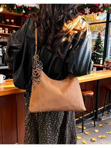 Brown hobo shoulder bag detail, stylish PU leather tote with chic letter charm and strap.