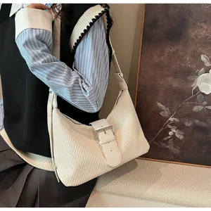 Detailed view of the off-white textured shoulder bag with chic buckle and elegant retro strap.