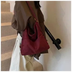 Vista dettagliata della borsa a spalla in camoscio bordeaux con grande capienza e tasca.