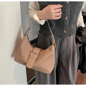Detailed view of brown striped underarm shoulder bag with vintage buckle strap design.
