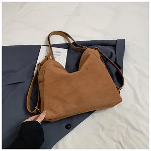 Dettaglio zaino a spalla in camoscio marrone, borsa vintage casual per uso quotidiano.