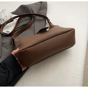 Vintage brown pleated underarm shoulder bag with textured embossed leather and buckle.