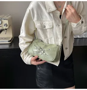 Detailed view of light green motorcycle shoulder bag with buckle straps and metal eyelet accents.