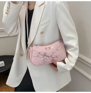 Pink PU leather shoulder bag with motorcycle style buckles and metal grommets for women.