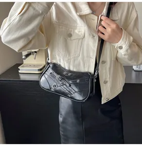 Black motorcycle shoulder bag with buckle straps and metal eyelets, stylish women bag.