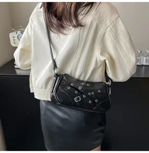 Black motorcycle leather shoulder bag for women with multi buckle straps and metal eyelets.