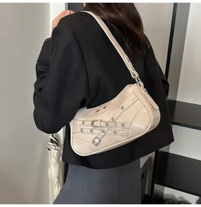 Detailed view of a beige motorcycle shoulder bag with leather straps and metal grommets.