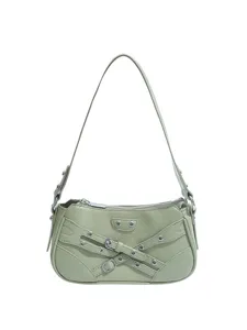 Light green motorcycle shoulder bag with vintage buckle straps and metal eyelets for women.