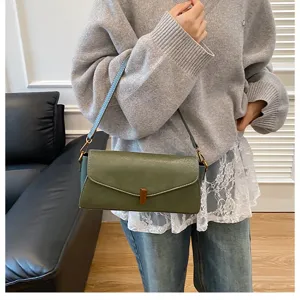 Detail shot of the stylish green leather shoulder bag showcasing flap closure and metal hardware.