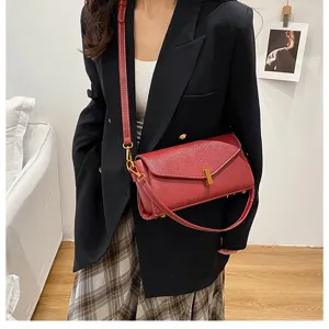 Detailed shot of a stylish red leather shoulder bag with chic metal lock and slim strap.