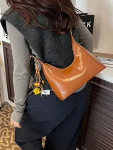 Stylish retro glossy leather hobo shoulder bag with chic tassel charm for daily women.
