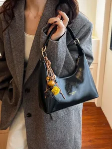 Black glossy leather hobo bag for women, vintage underarm handbag with chic charms.