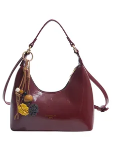 Glossy vintage PU leather hobo shoulder handbag for women featuring stylish tassel and bead charm.