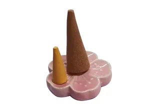 Detailed shot of a ceramic cherry blossom incense holder with two aromatic cones.