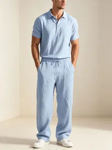 Men's light blue casual linen polo shirt and matching loose trousers summer outfit detail view