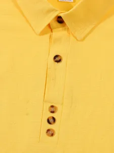 Close-up detail of yellow cotton linen shirt collar, buttons and placket texture view.