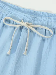 Detail shot of men's casual light blue shorts waistband and white adjustable drawstring design.