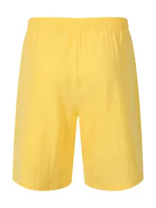 Detail view of casual yellow men's shorts featuring an elastic waistband and crinkled fabric texture.