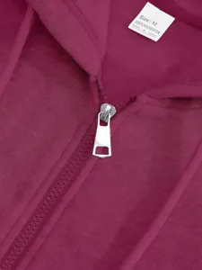 Close up view of purple hoodie zipper and fabric detail, showing soft fleece texture.