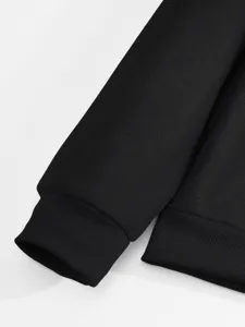 Primo piano del polsino e dell'orlo a costine di una felpa nera, morbida trama in maglia.