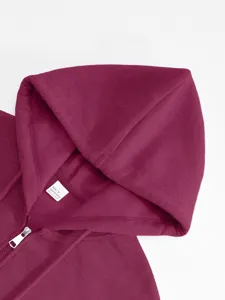 Dettaglio del colletto della felpa bordeaux, zip in metallo e morbida consistenza del tessuto.