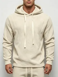 Close-up detail of the cozy beige fleece hoodie texture and adjustable hood drawstring.