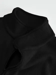 Close-up detail shot of men's black ribbed stand-collar jacket with smooth zipper.