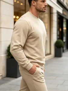 Men's minimalist solid color crewneck sweatshirt and casual pants outfit detail view