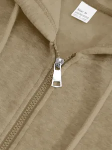 Close-up view of a khaki hoodie collar, metal zipper, and polyester care label detail.