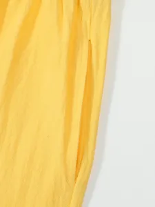 Men's casual shorts side pocket detail, premium yellow linen fabric close-up presentation.