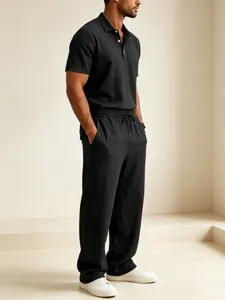 Detail shot of black cotton linen casual short sleeve polo shirt and loose long pants set for men.
