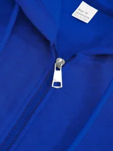 Close-up detail shot of royal blue zip hoodie collar, showing zipper and size tag texture.