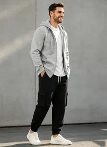 Detail view of men casual outfit, gray hoodie and black cargo pants in urban setting.