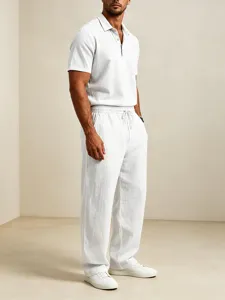 Men's casual white short sleeve polo shirt and breathable loose linen trousers outfit detail.