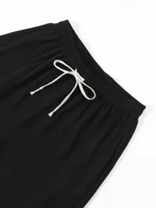 Close-up of men's casual black trousers waistband with adjustable white drawstring design.