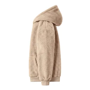 Close-up detail of soft fluffy fleece hooded sweatshirt in beige, cozy winter texture and front pocket.