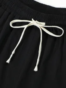 Detailed view of black casual shorts featuring an adjustable white drawstring waist.