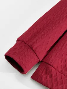 Close-up view of men's burgundy jacquard fabric garment sleeve cuff and textured fabric detail.