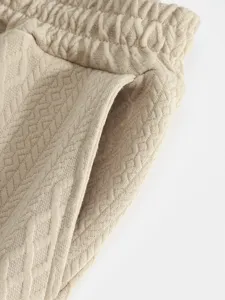 Men's casual pants detail shot, premium jacquard fabric texture close-up display.