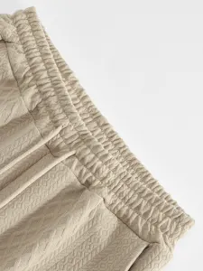 Detail shot of men's casual pants elastic waistband with jacquard texture design fabric.