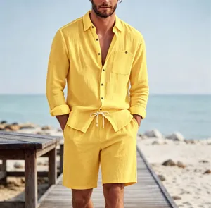 Detail shot of men's yellow linen long sleeve shirt and shorts set on beach boardwalk background.