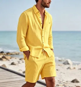 Detail view of men linen long sleeve shirt and shorts set on beach scene outdoors.