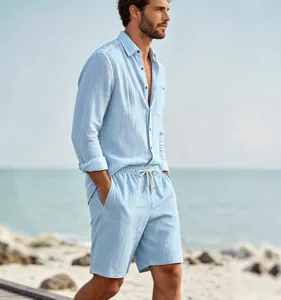 Detail shot of men's casual light blue linen long-sleeve shirt and shorts beach set.