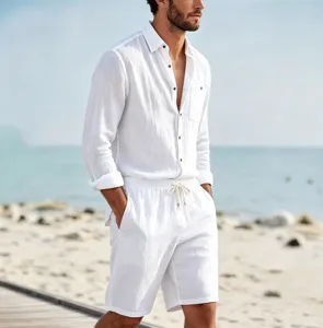 Detail view of men's solid linen long sleeve shirt and casual shorts set on beach backdrop.