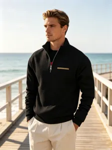 Detail shot of a men's black stand-collar half-zip sweatshirt on a scenic wooden boardwalk.