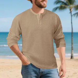 Detailed view of men's casual long sleeve waffle Henley shirt in khaki, featuring button placket.